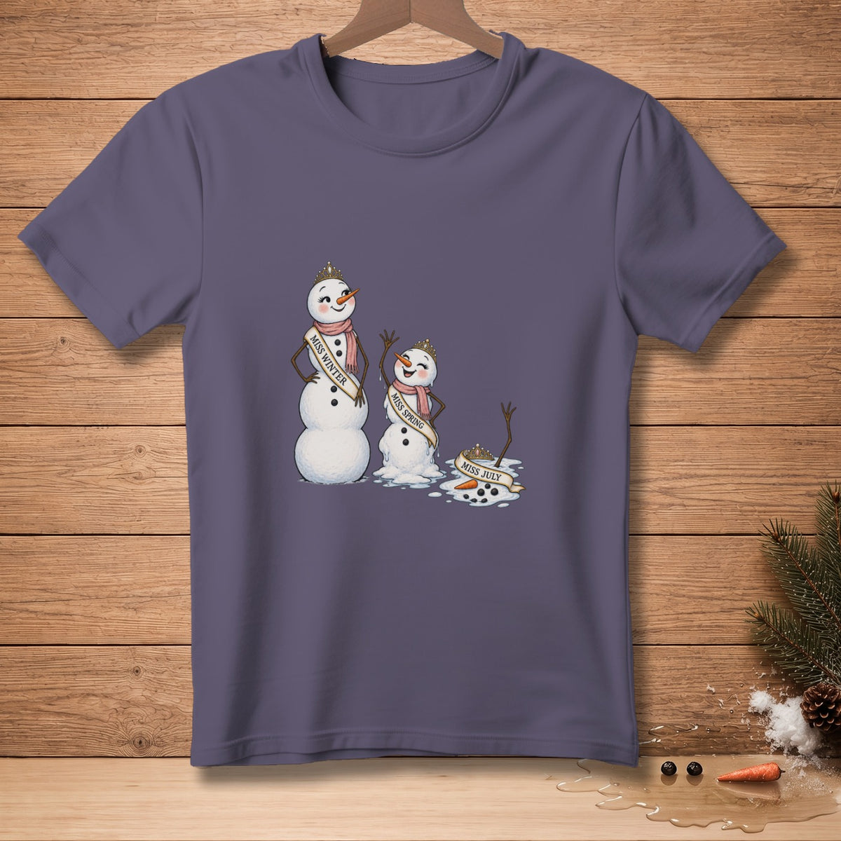 Three melting snowmen, Miss Winter, Miss Spring, and Miss July, on a t-shirt.