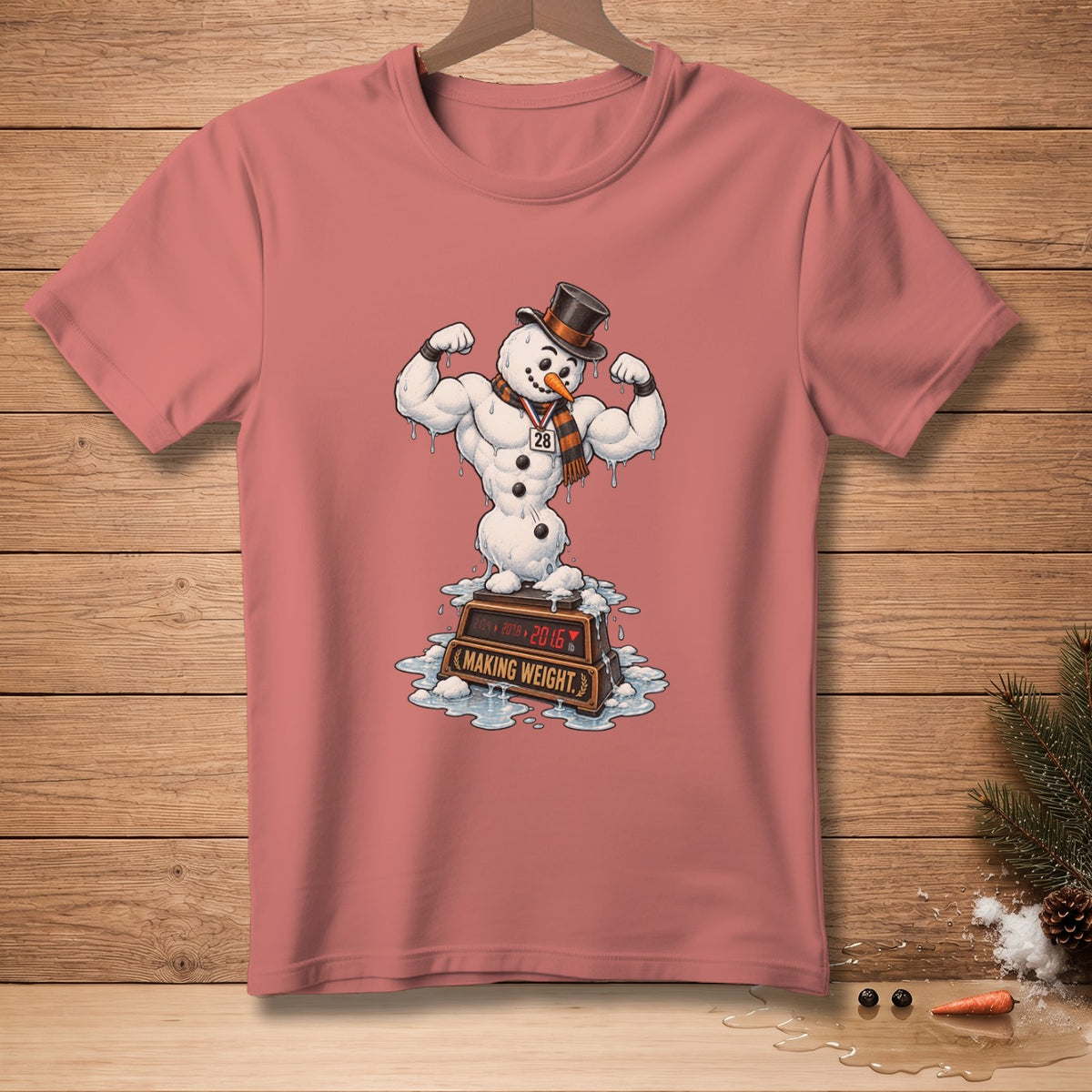 T-shirt graphic of a muscular snowman flexing on a weight scale.