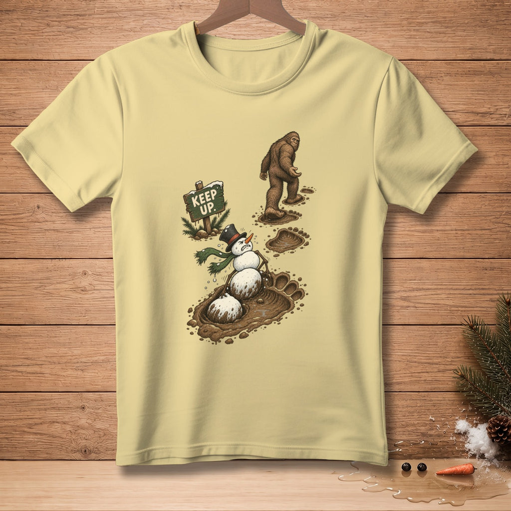 Bigfoot walks past a melting snowman with a sign saying "Keep Up."