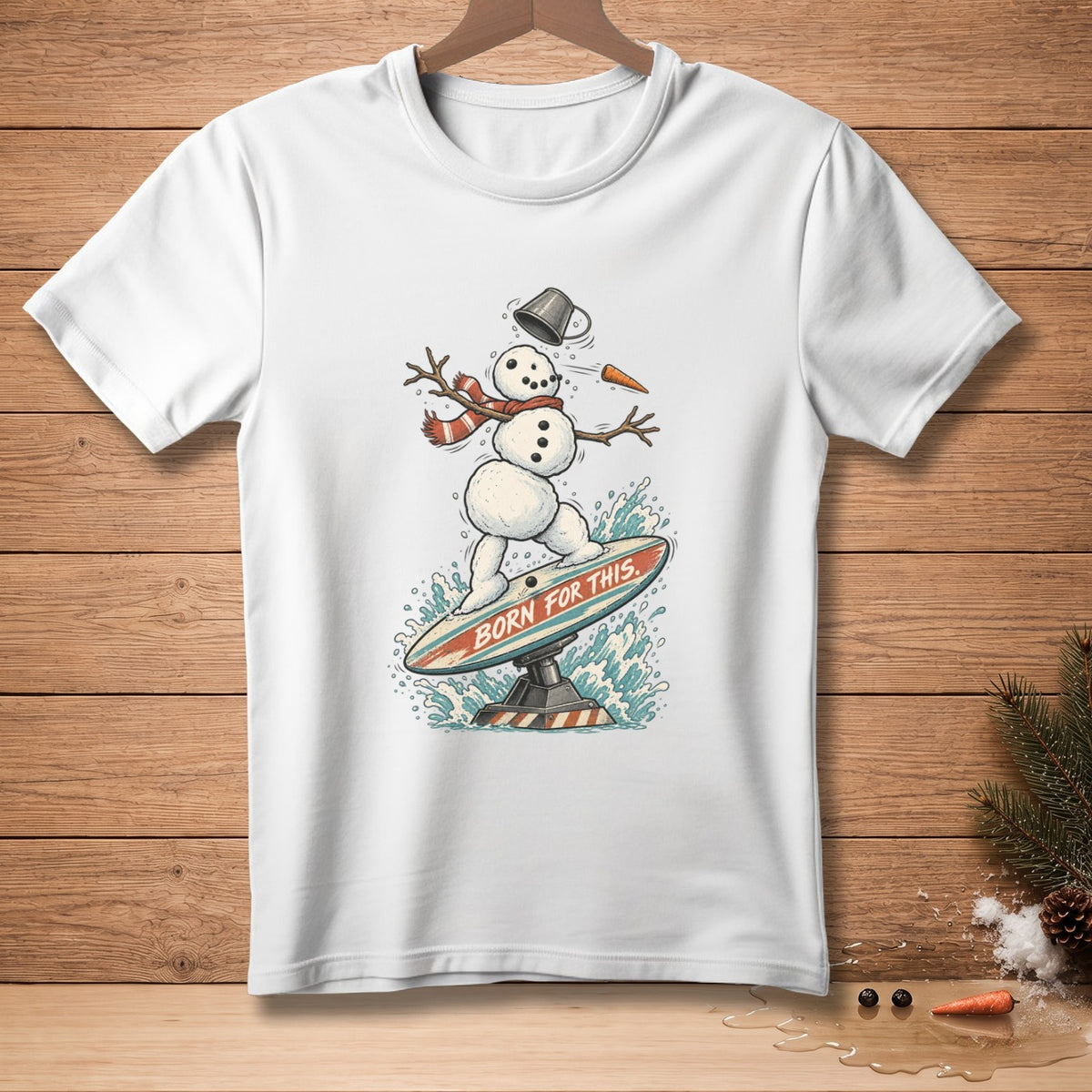White t-shirt with snowman surfing on a board, "BORN FOR THIS" text.