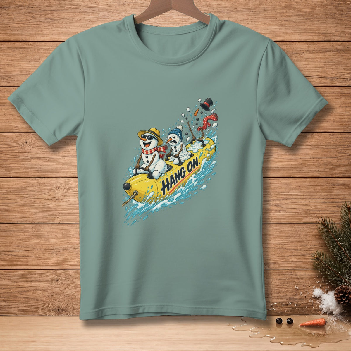 T-shirt with graphic of snowmen on a banana boat with "Hang On" text.