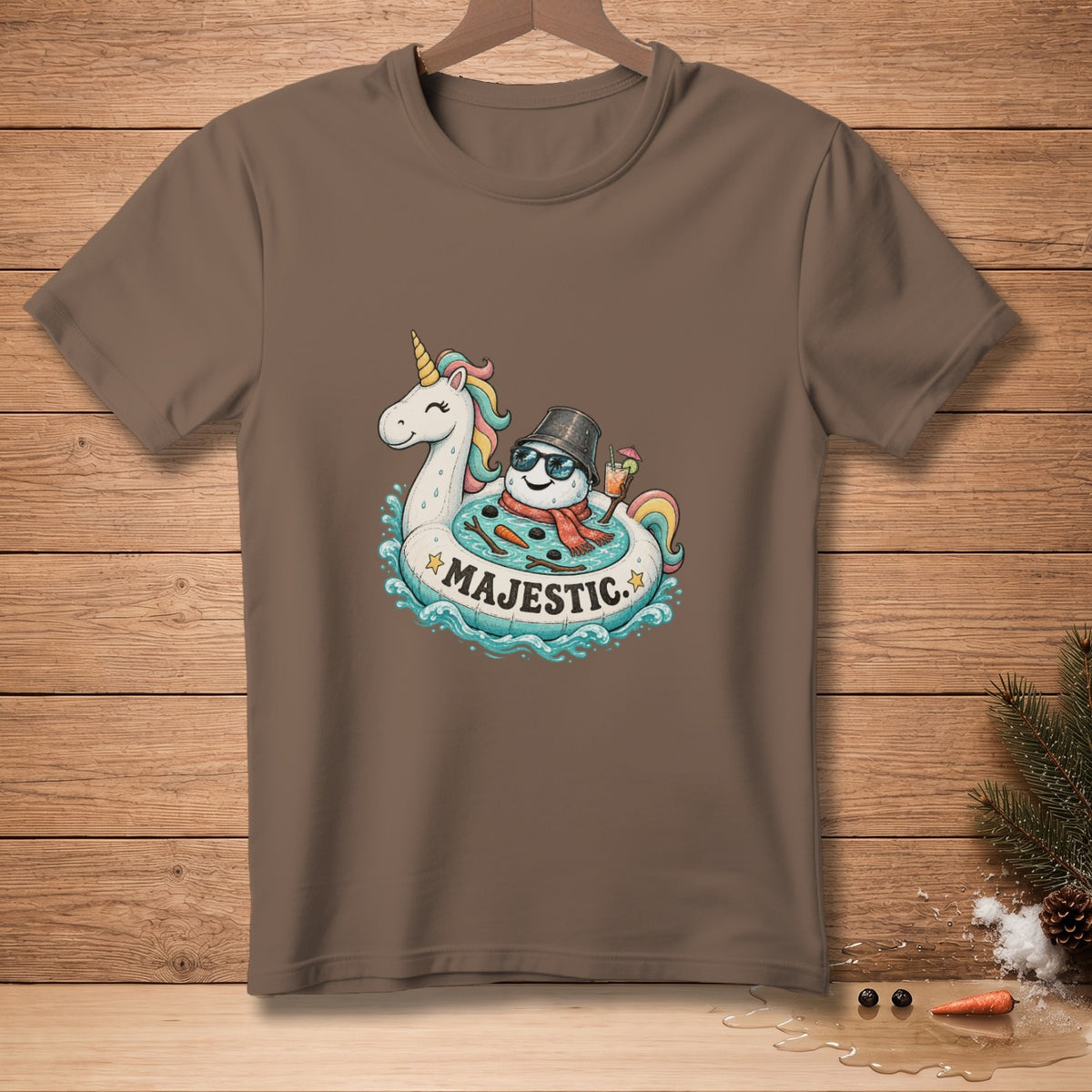 Brown t-shirt with a cartoon of a snowman and unicorn on a pool float.