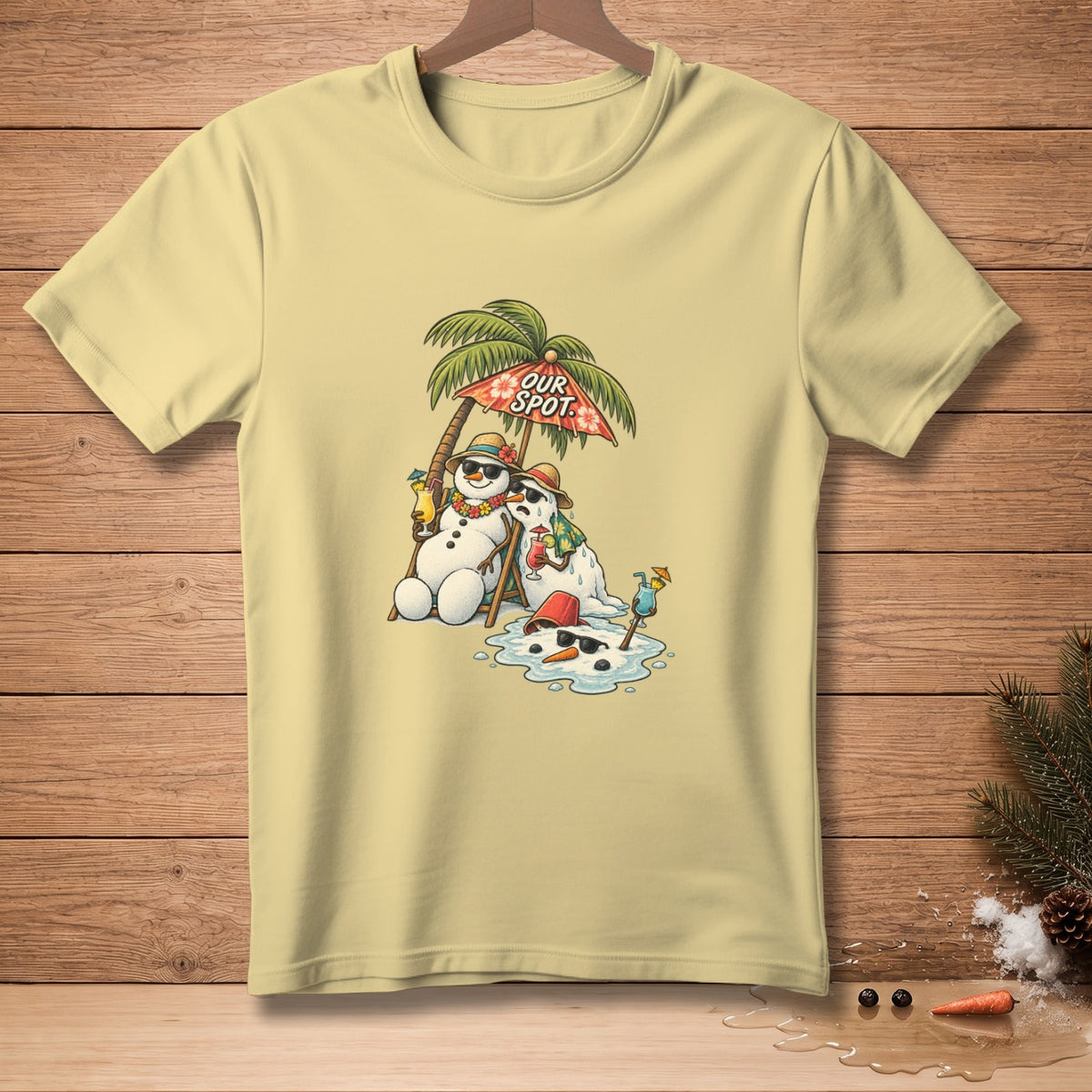 Light yellow t-shirt with graphic of melting snowmen on beach chairs under an umbrella.