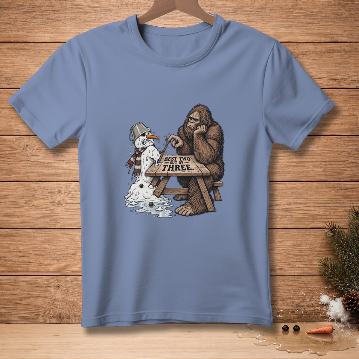 Bigfoot and a melting snowman sit at a table with text "BEST TWO OUT OF THREE".