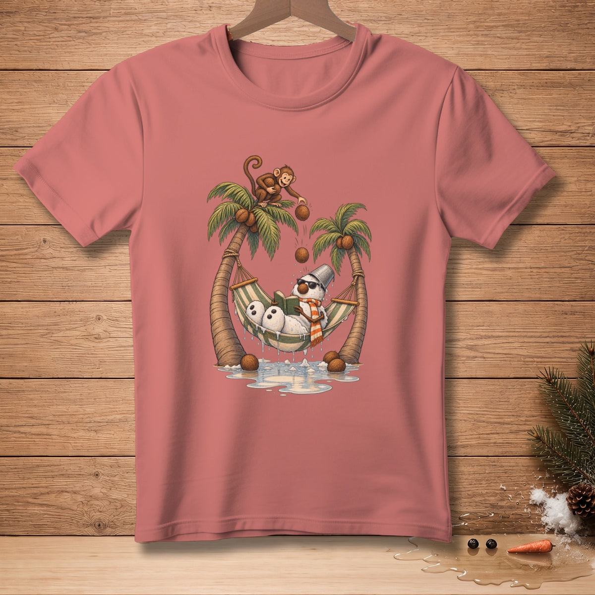 T-shirt graphic of a snowman reading in a hammock between palm trees while a monkey drops coconuts.
