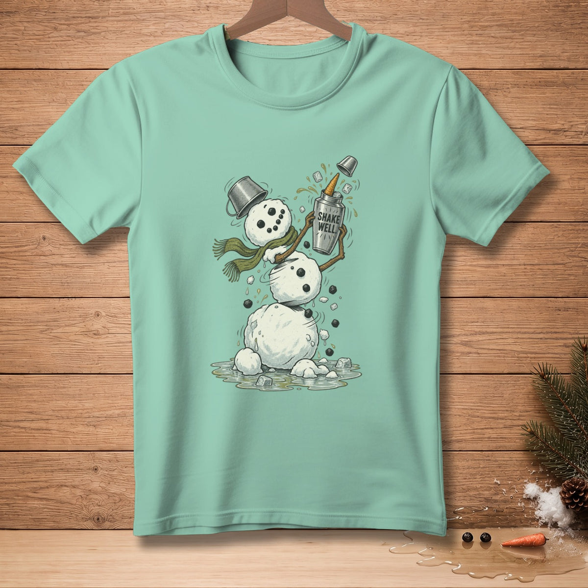 Mint green t-shirt with a snowman graphic shaking a bottle labeled "Shake Well".