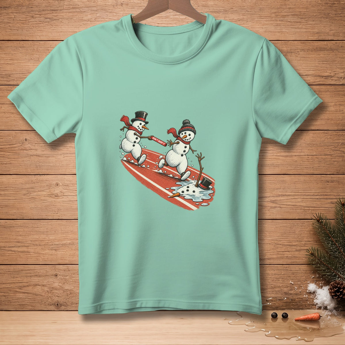 Two snowmen on a surfboard, one holding a "Don't Drop It" banner.