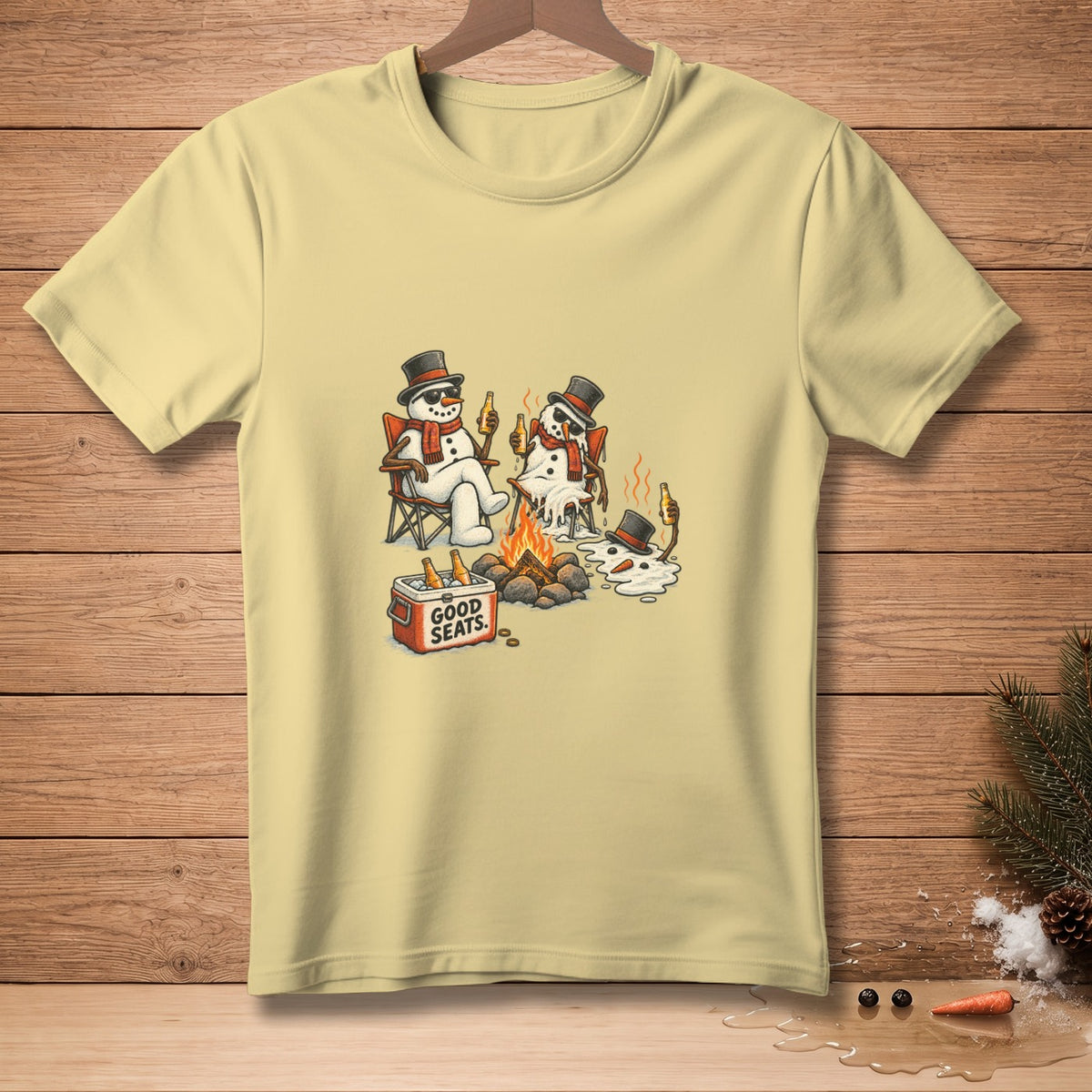 T-shirt graphic of melting snowmen with top hats by a campfire, text "GOOD SEATS".