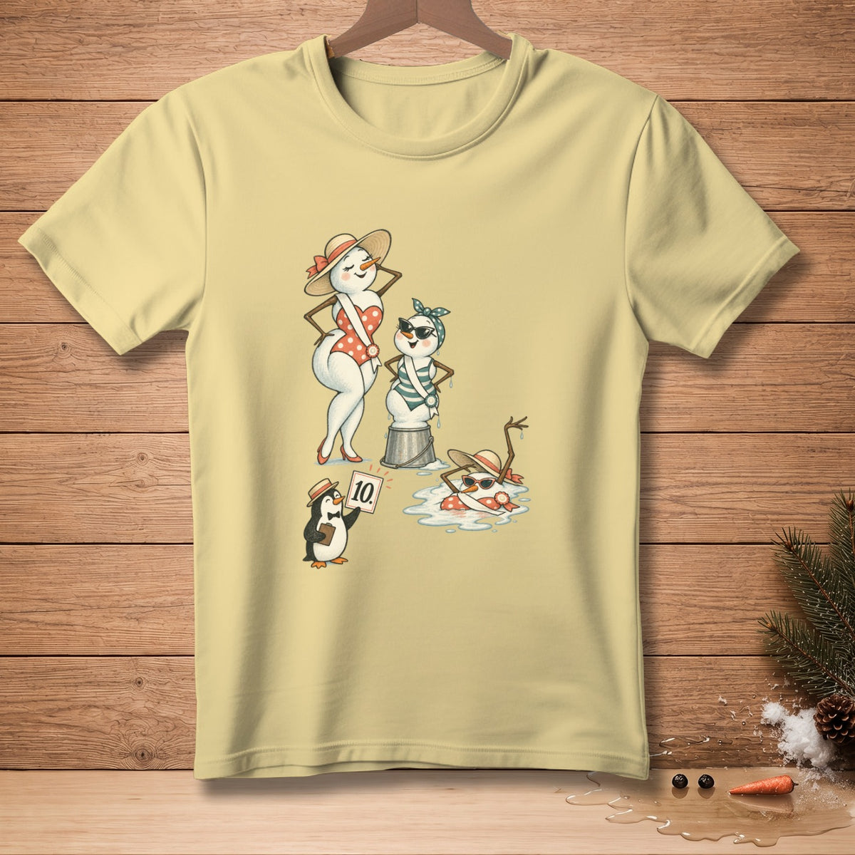 Three snowmen in swimsuits, a penguin holding a "10" sign, on a yellow t-shirt.