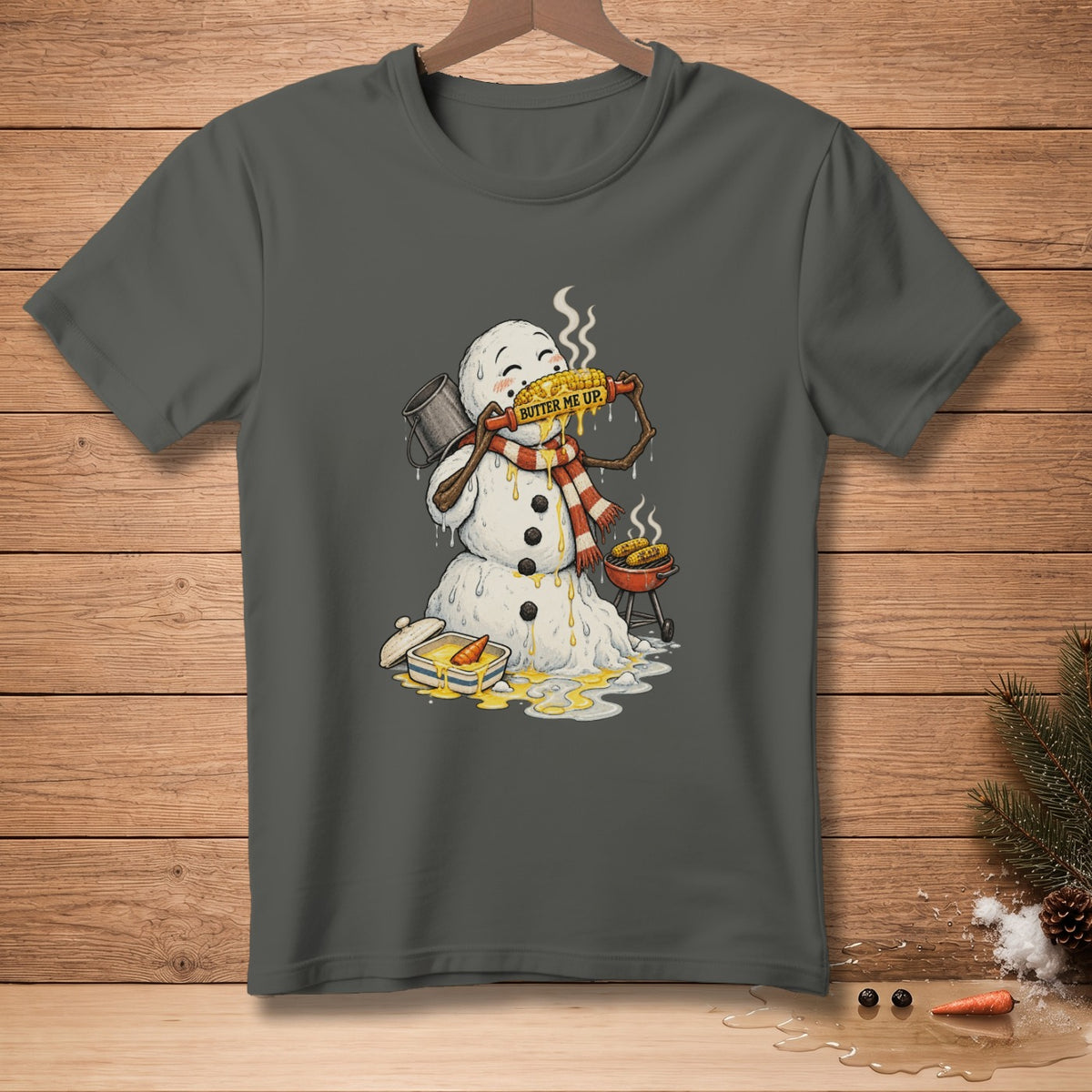 Snowman with scarf eating corn on the cob saying "Butter Me Up".