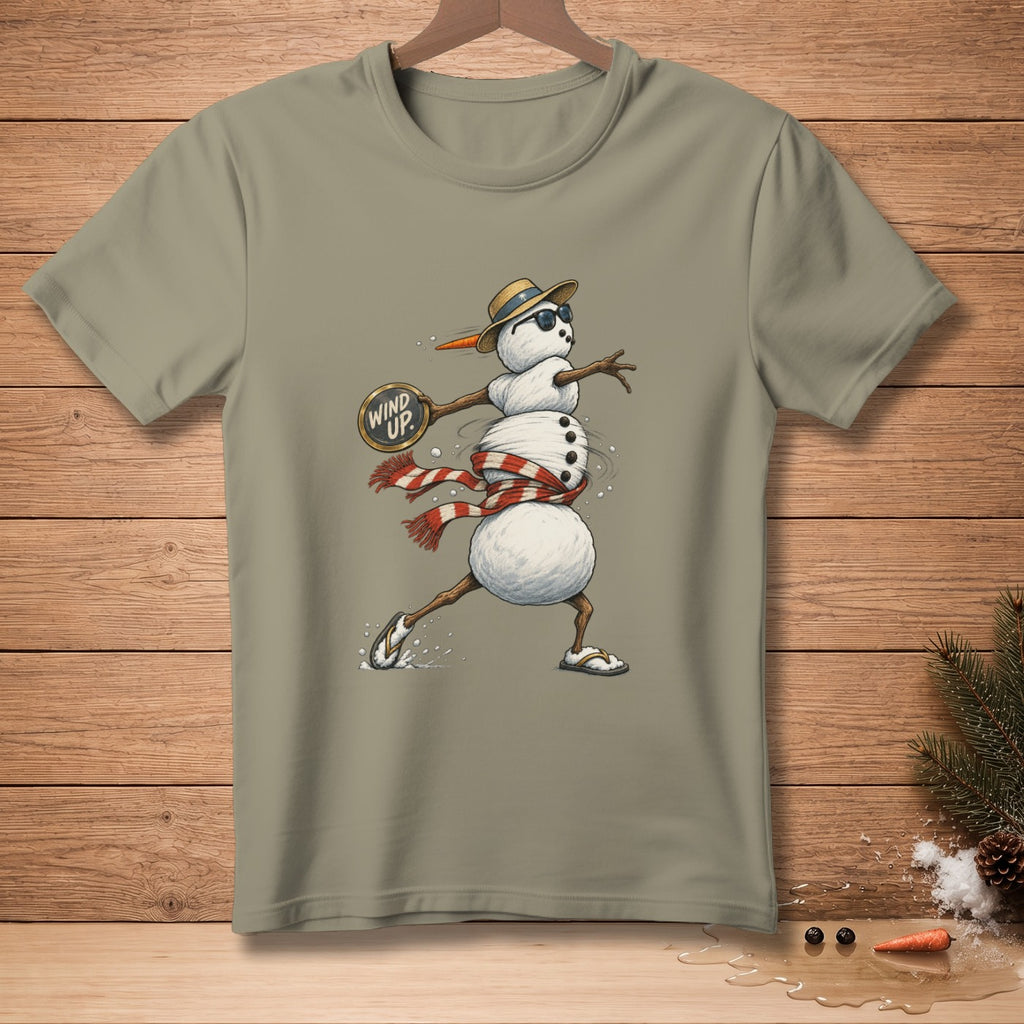 Snowman wearing a hat and sunglasses, with a "Wind Up" sign, is depicted on a taupe t-shirt.