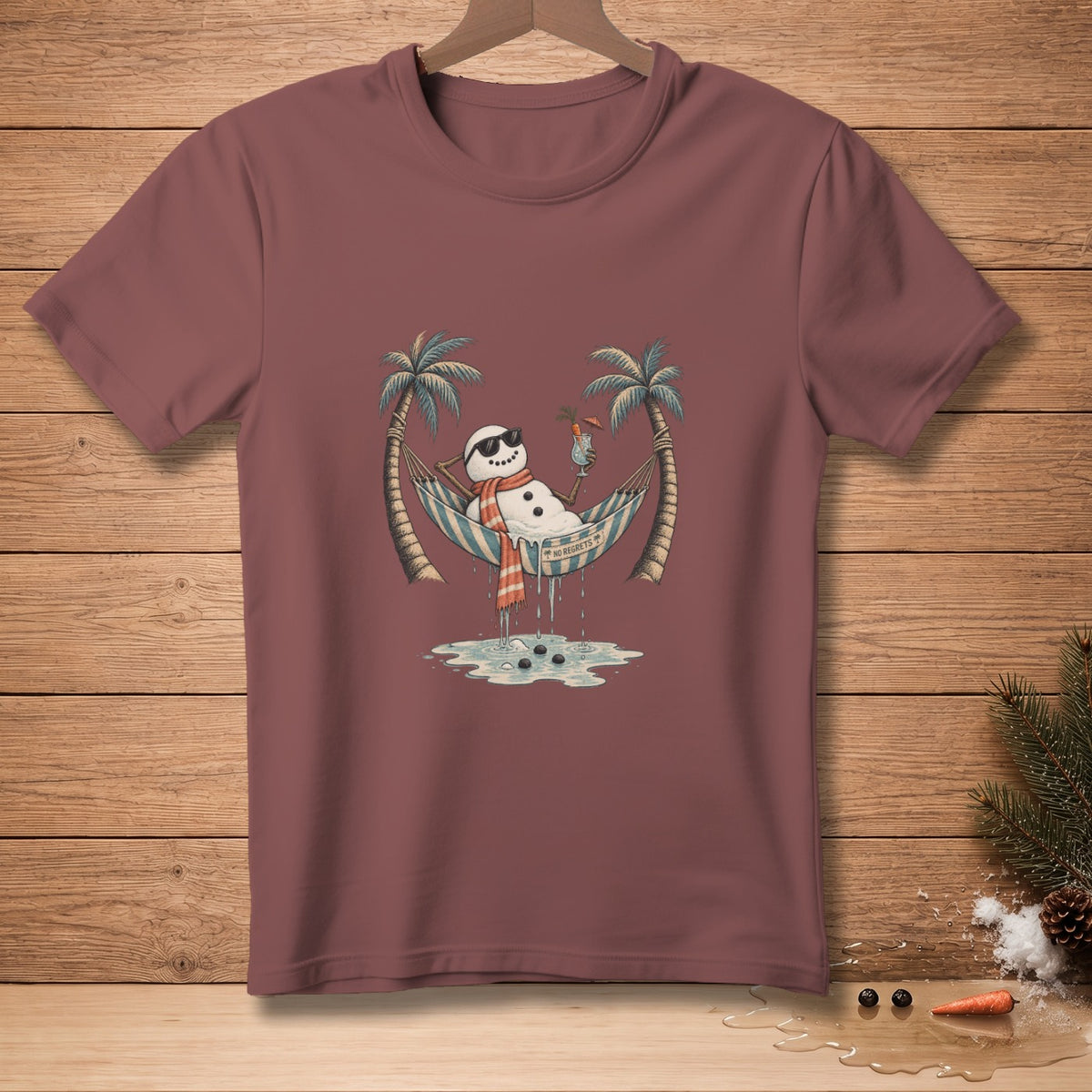 Snowman in sunglasses relaxing in a hammock between palm trees, text reads "No Regrets".