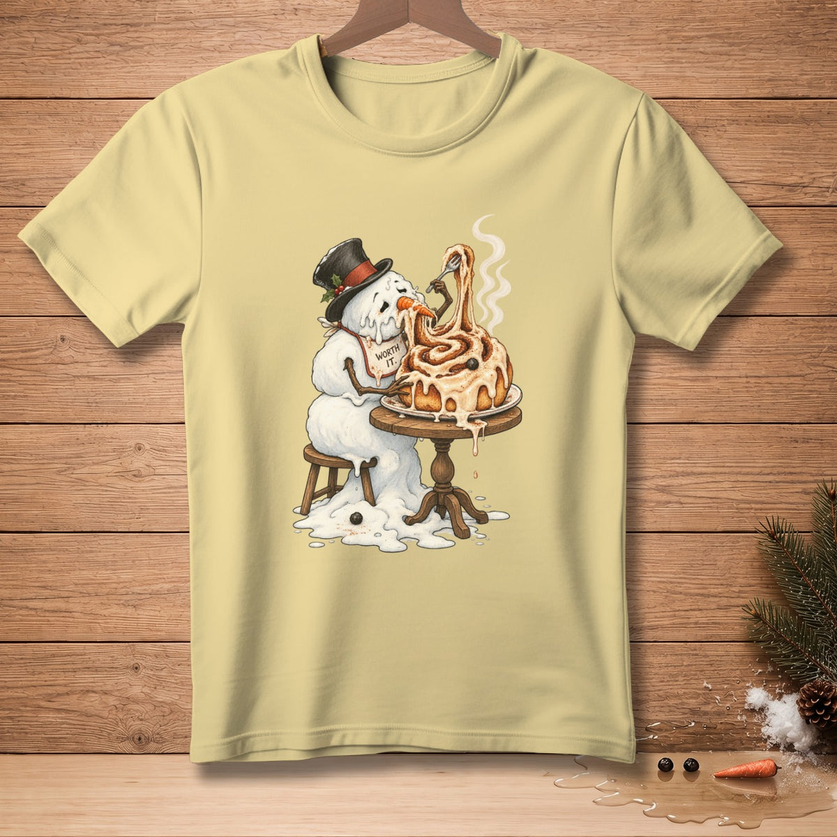 Melting snowman wearing top hat eats cinnamon roll with fork, "Worth It." text on bib.
