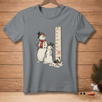 Two snowmen stand next to a ruler measuring growth, one is taller.