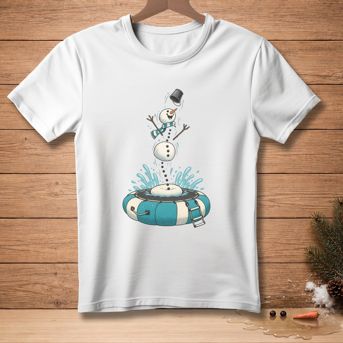 White t-shirt with graphic of a snowman jumping into a blue and white inflatable ring.