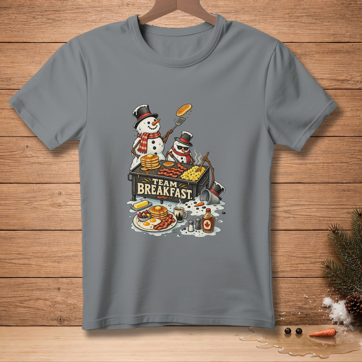Two snowmen cook a breakfast feast on a griddle that reads "TEAM BREAKFAST."