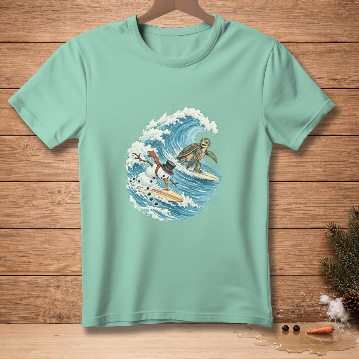 Snowman and sea turtle surfing a wave on a light teal t-shirt.