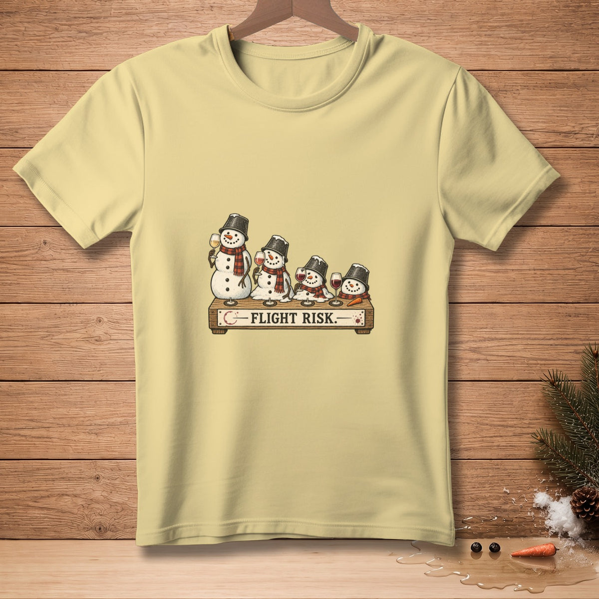 Light yellow t-shirt with snowmen holding wine glasses and the text "FLIGHT RISK."