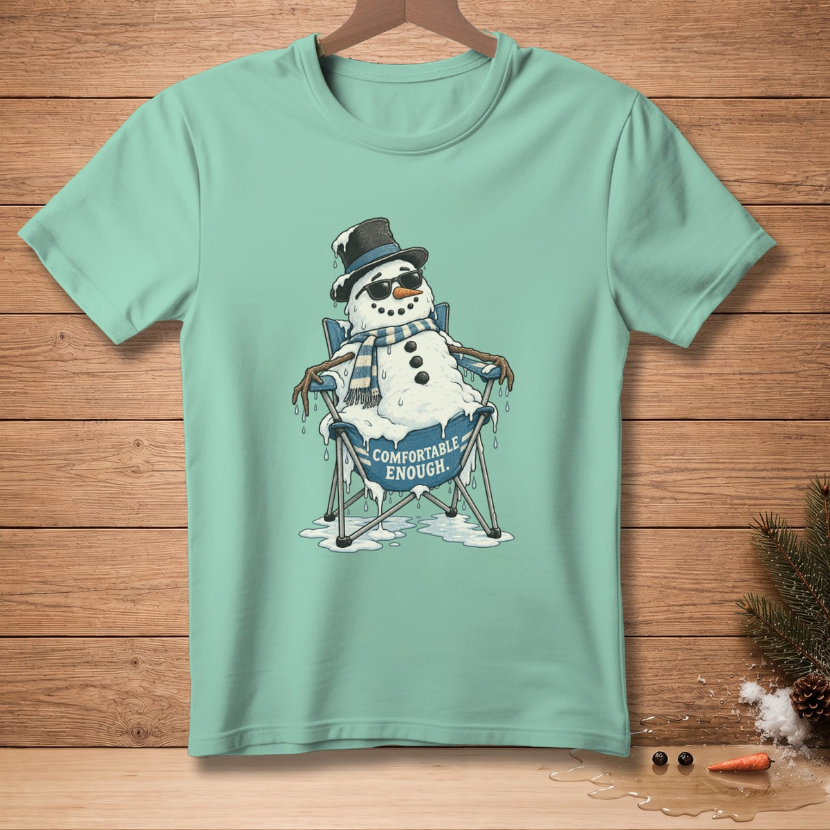 Melting snowman in a chair with sunglasses and scarf, "COMFORTABLE ENOUGH." text.