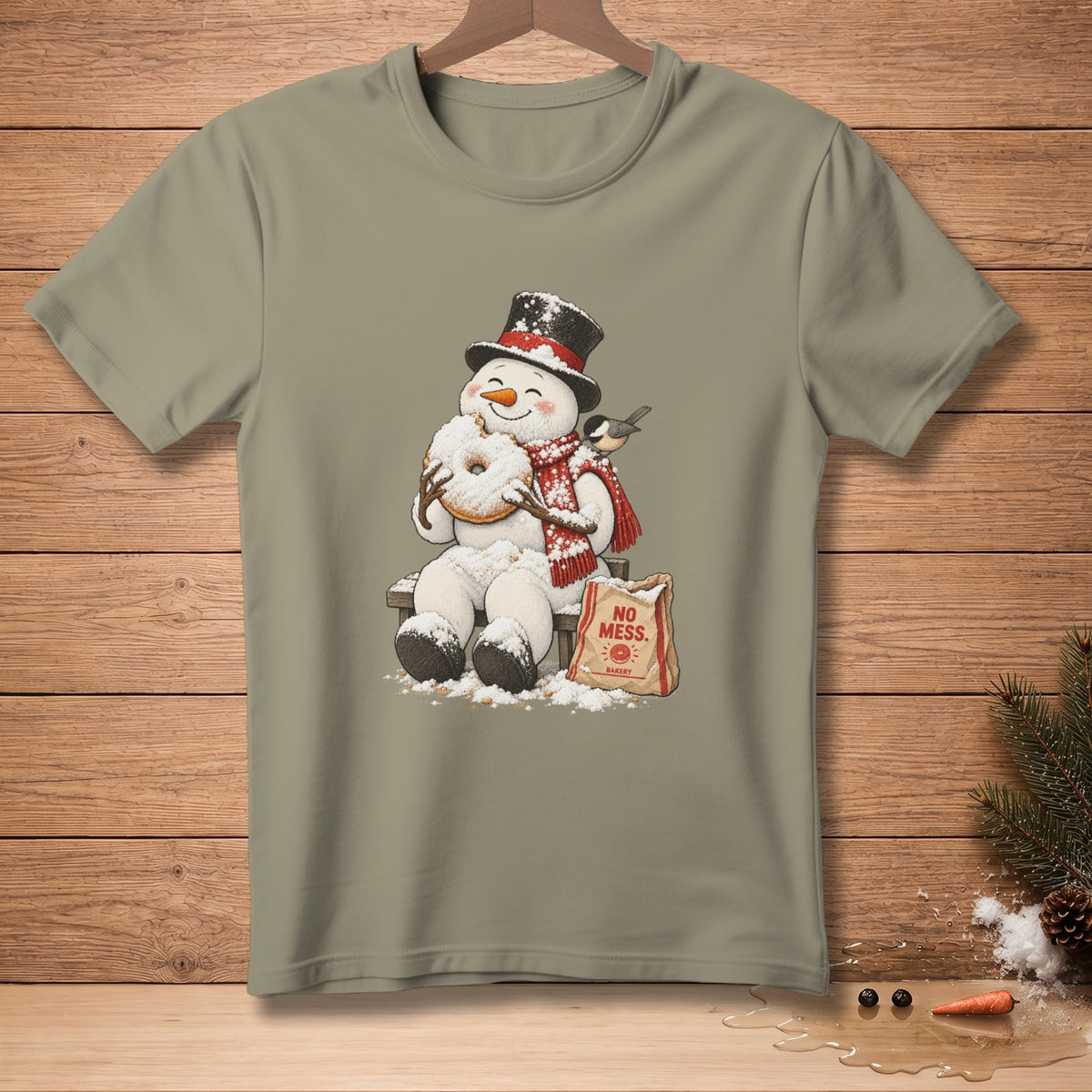 Snowman with donut and "No Mess Bakery" bag on t-shirt.