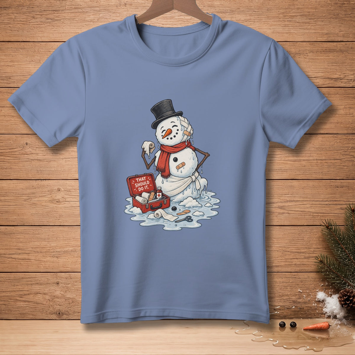 Melting snowman with bandages, a red first-aid kit, and scissors on a t-shirt.