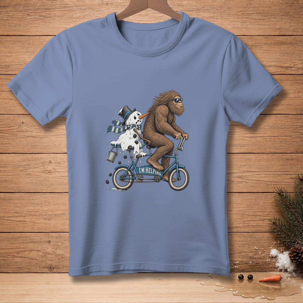 Bigfoot rides a tandem bicycle with a melting snowman, text "I'M HELPING".