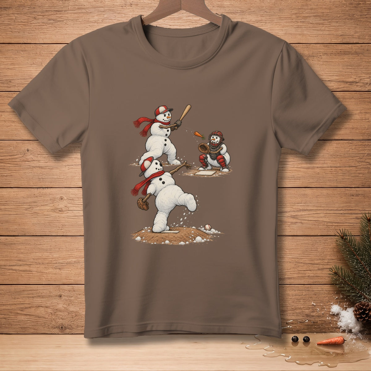 Snowmen play baseball with a pitcher, batter, and catcher on a brown t-shirt.