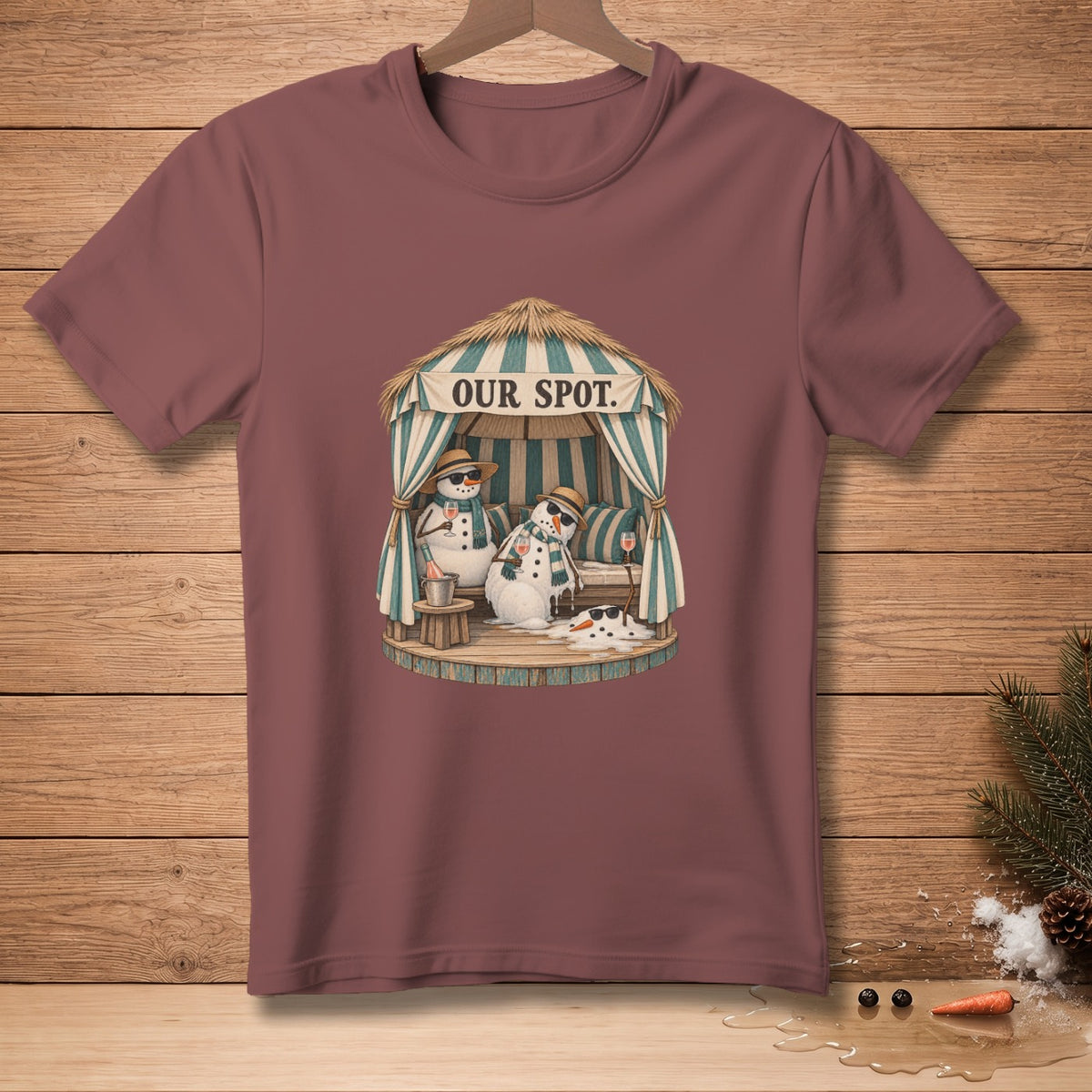 T-shirt graphic of two snowmen relaxing under a cabana with text "OUR SPOT".