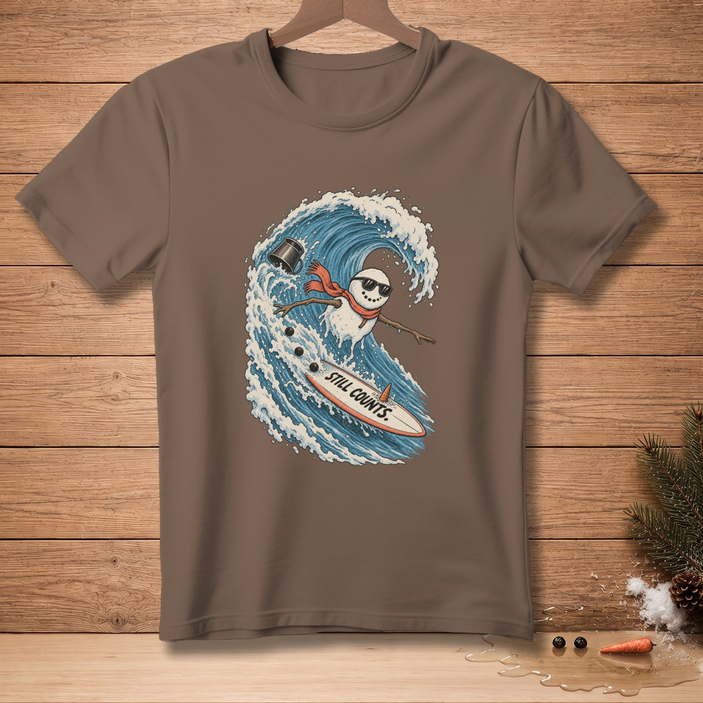 Snowman surfing a wave on a surfboard with text "STILL COUNTS."