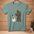 Bigfoot holding a stick next to a snowman with a top hat and scarf.