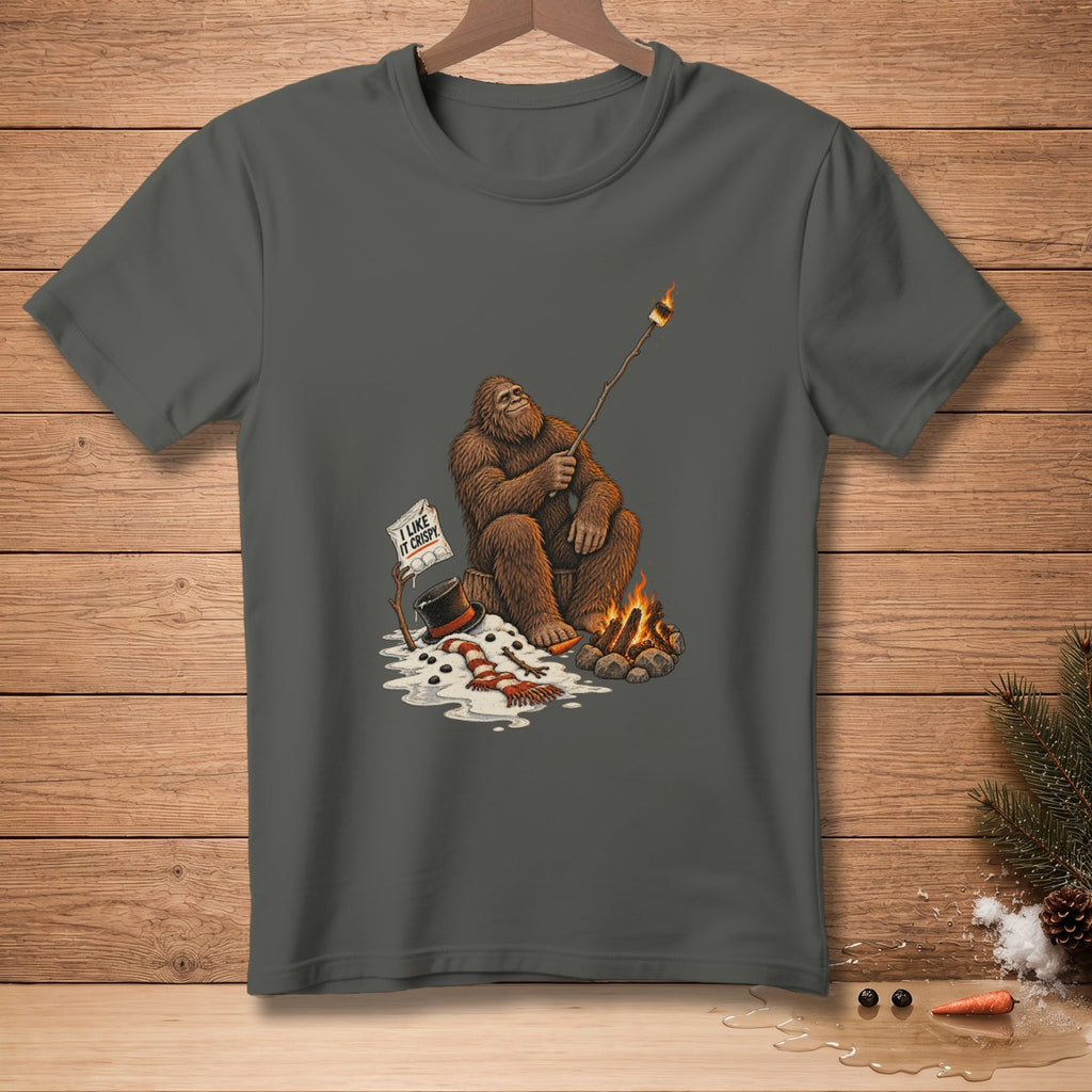 Bigfoot roasting a marshmallow over a campfire with "I like it crispy" sign.