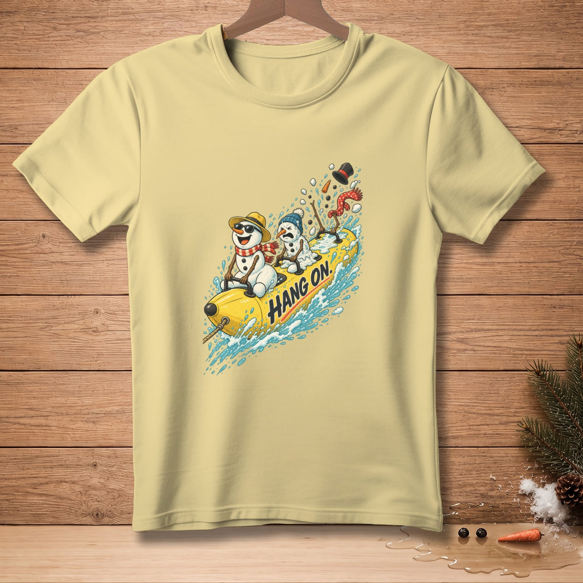 Yellow t-shirt with a graphic of snowmen on a yellow tube with "Hang On." text.