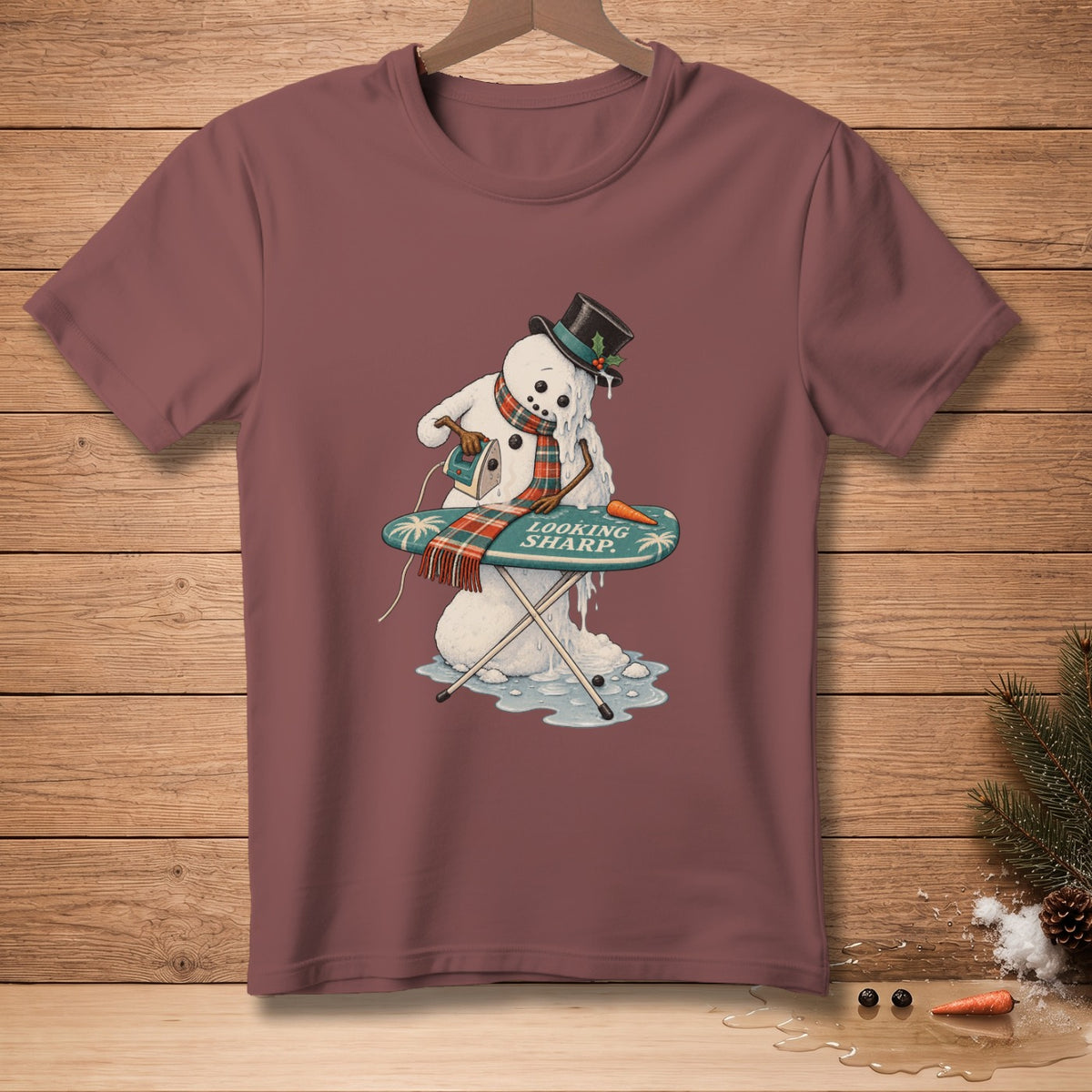 Melting snowman with iron and text "LOOKING SHARP" on ironing board.