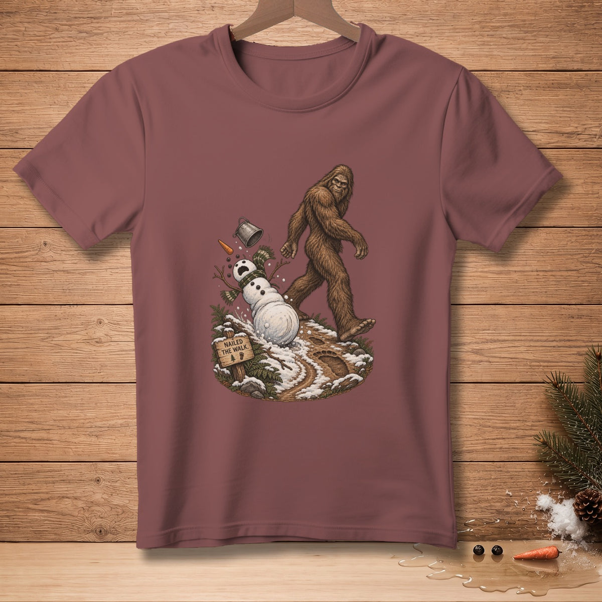 Bigfoot walking past a falling snowman with a sign that reads "Nailed the walk."
