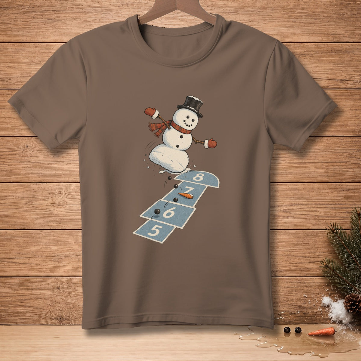 Snowman playing hopscotch on a brown t-shirt with a cartoon design.