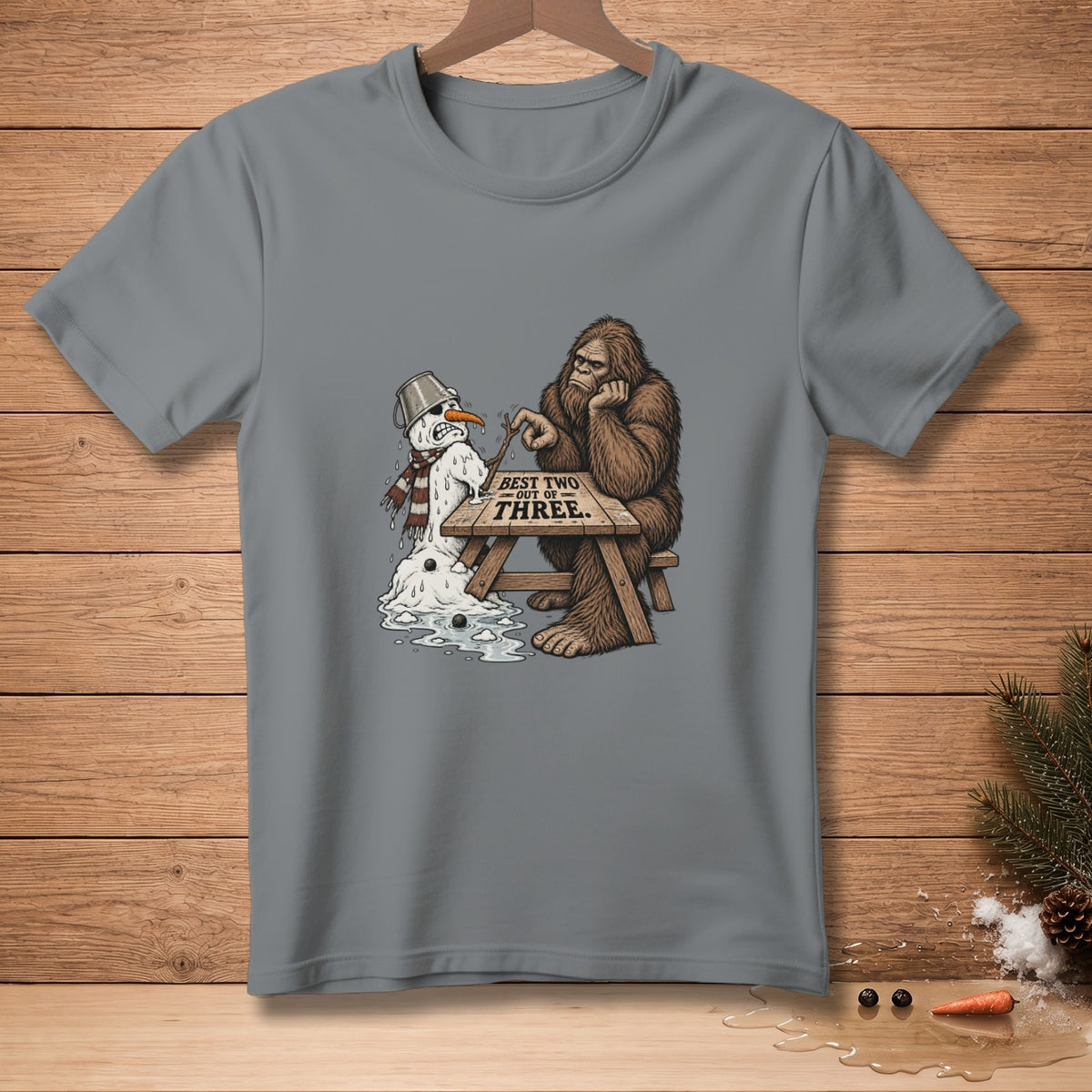 Bigfoot sits at a table with a melting snowman and text "BEST TWO OUT OF THREE".