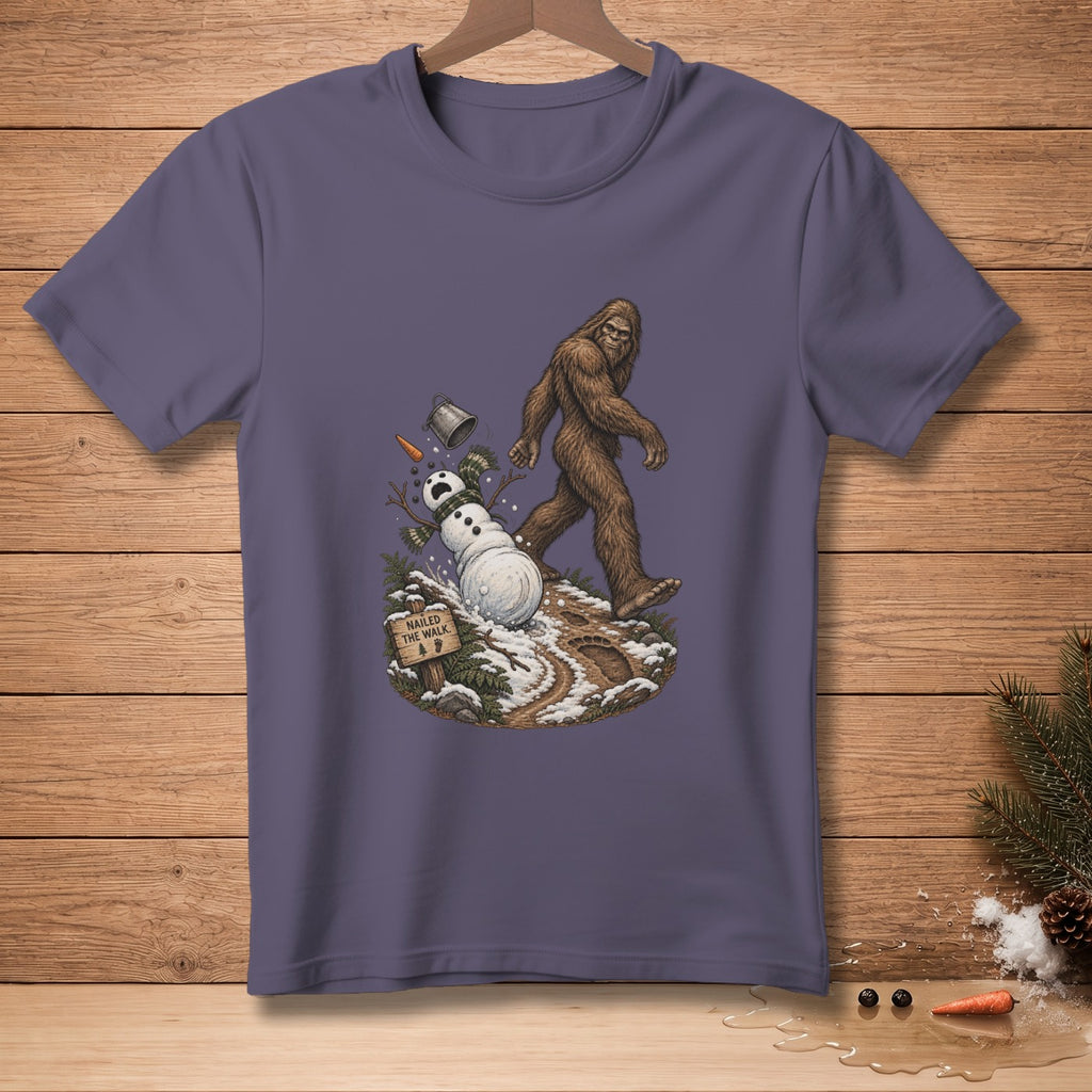 Bigfoot walks past a melting snowman with a sign reading "Nailed the Walk."