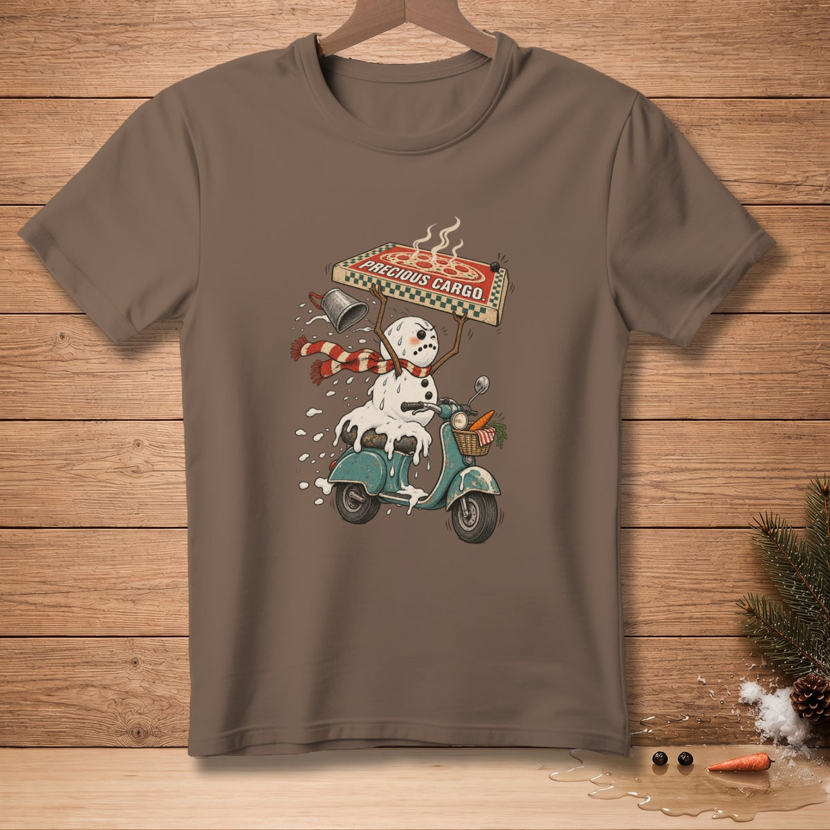 Brown t-shirt with a melting snowman on a scooter holding a pizza with text "PRECIOUS CARGO".