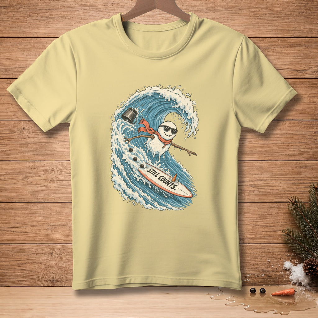 Snowman surfing a wave on a surfboard with text "STILL COUNTS".