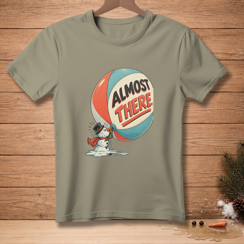 T-shirt graphic of a melting snowman holding a balloon with text "ALMOST THERE".