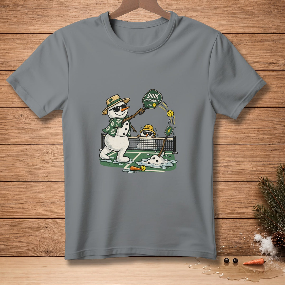 Two snowmen play pickleball on a court with melting snow and text "Dink Responsibly."