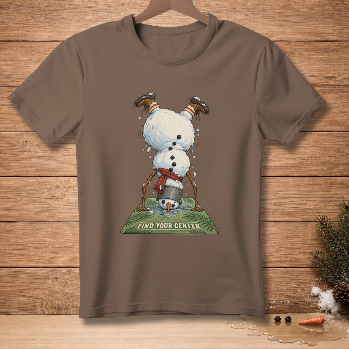 Brown t-shirt featuring a melting snowman in a handstand with text "FIND YOUR CENTER."