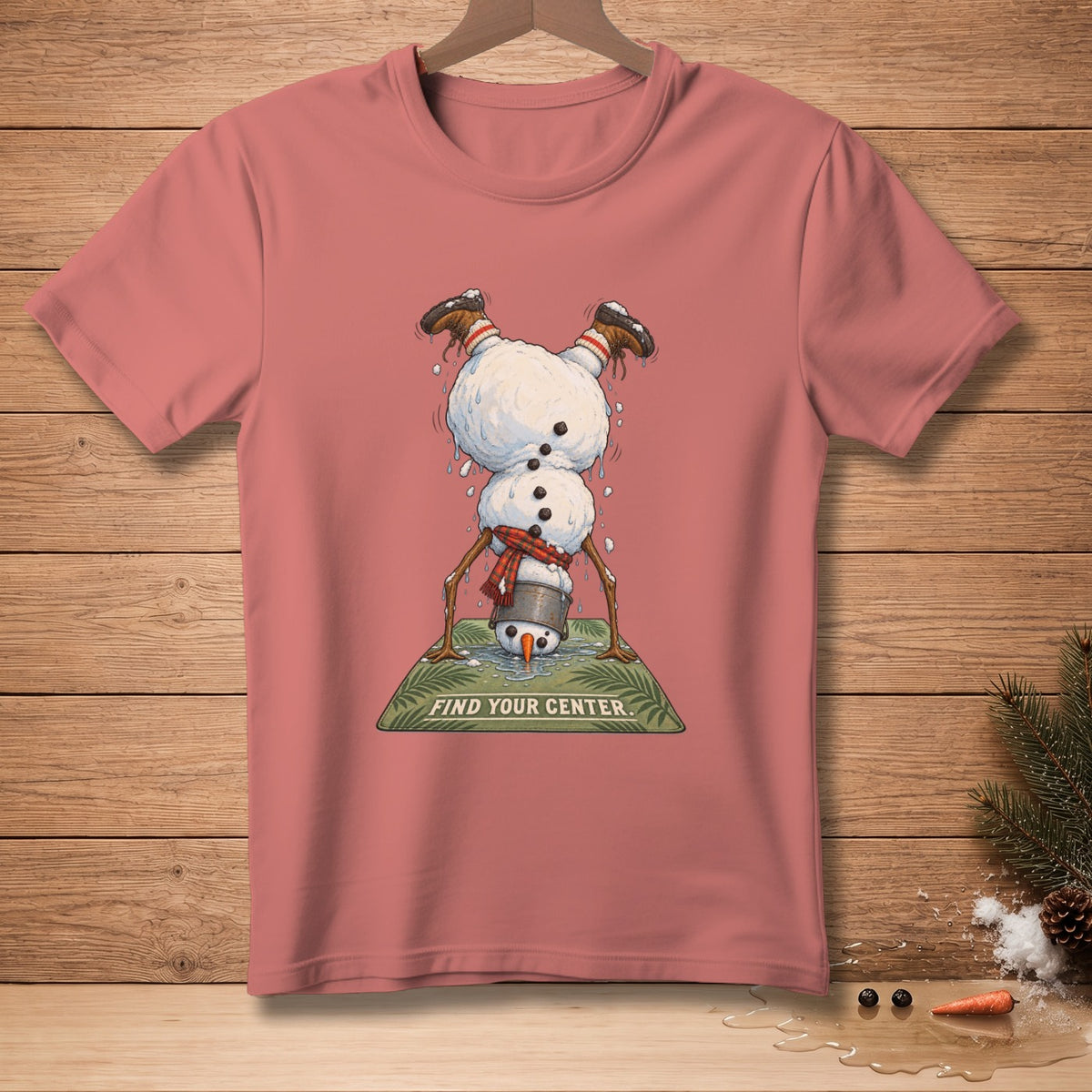 Pink t-shirt with upside-down snowman doing yoga and text "FIND YOUR CENTER".