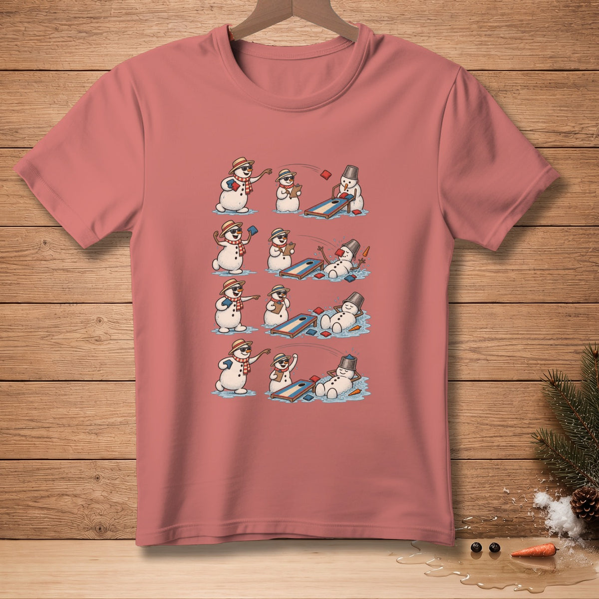 Snowmen playing cornhole in a comic strip sequence on a rose t-shirt.