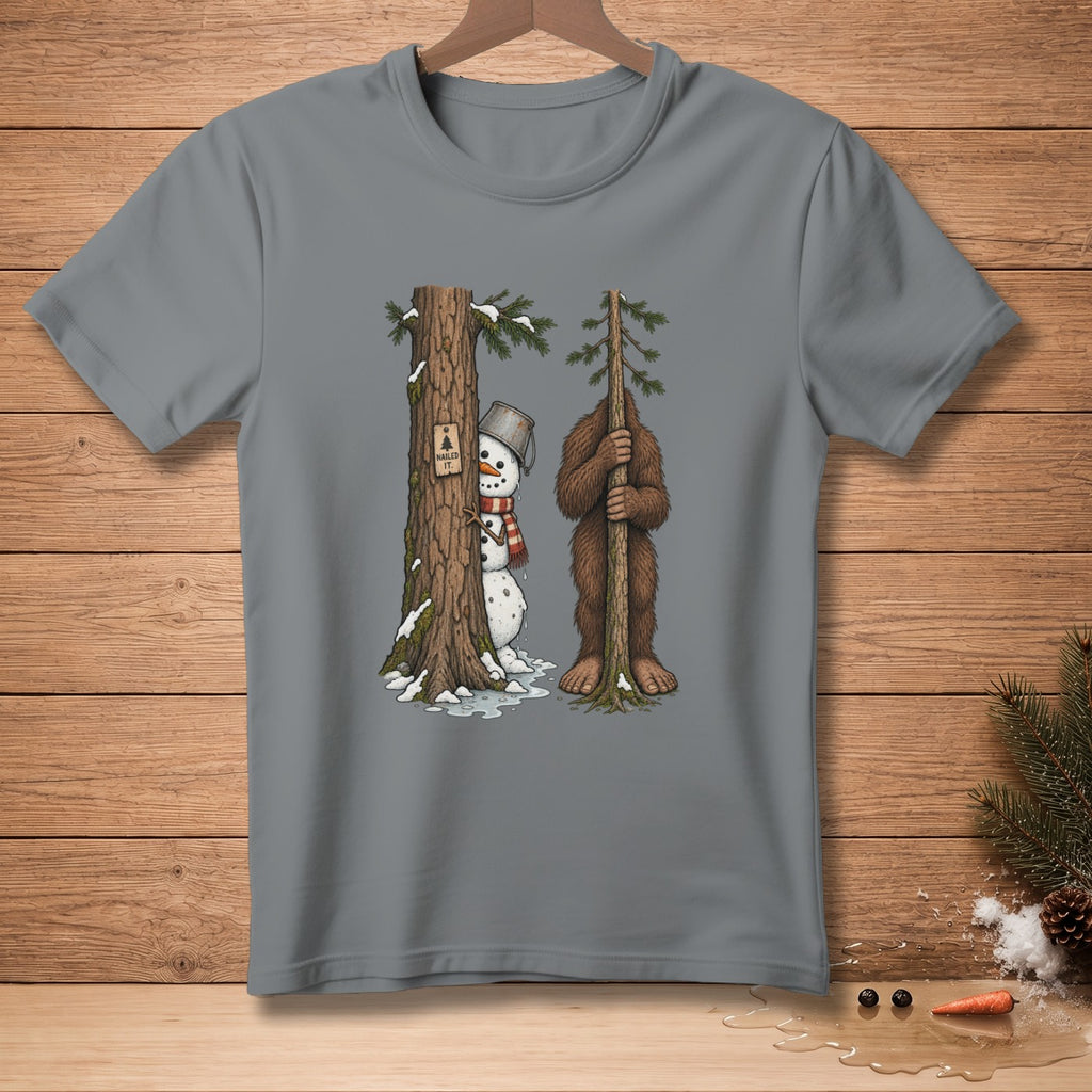 Snowman with bucket hat peeking from behind a tree next to Bigfoot holding a sapling.