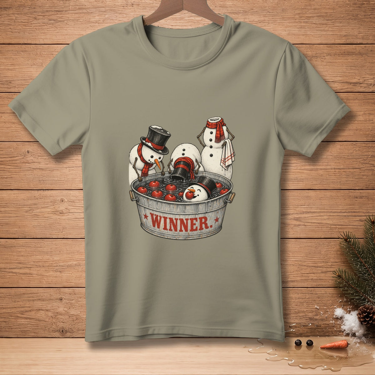 Snowmen bobbing for apples in a tub labeled "WINNER" on a t-shirt.