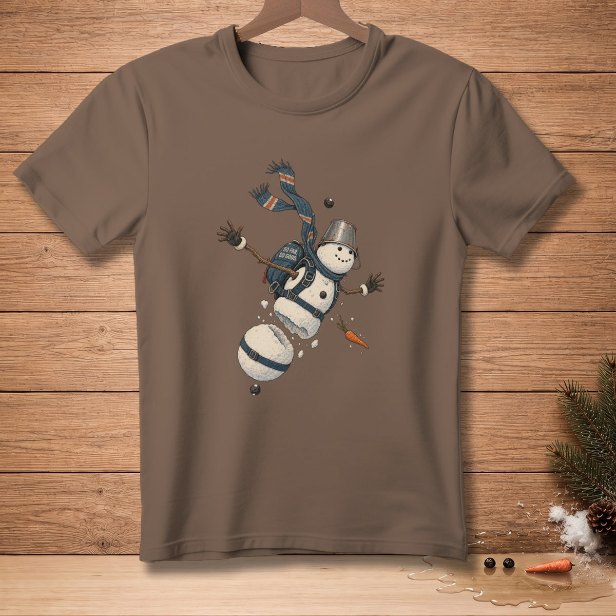 Brown t-shirt with a cartoon snowman falling apart with "So Far So Good" text.