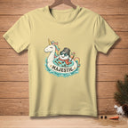 Yellow t-shirt with a cartoon unicorn and snowman on an inner tube, saying "Majestic."