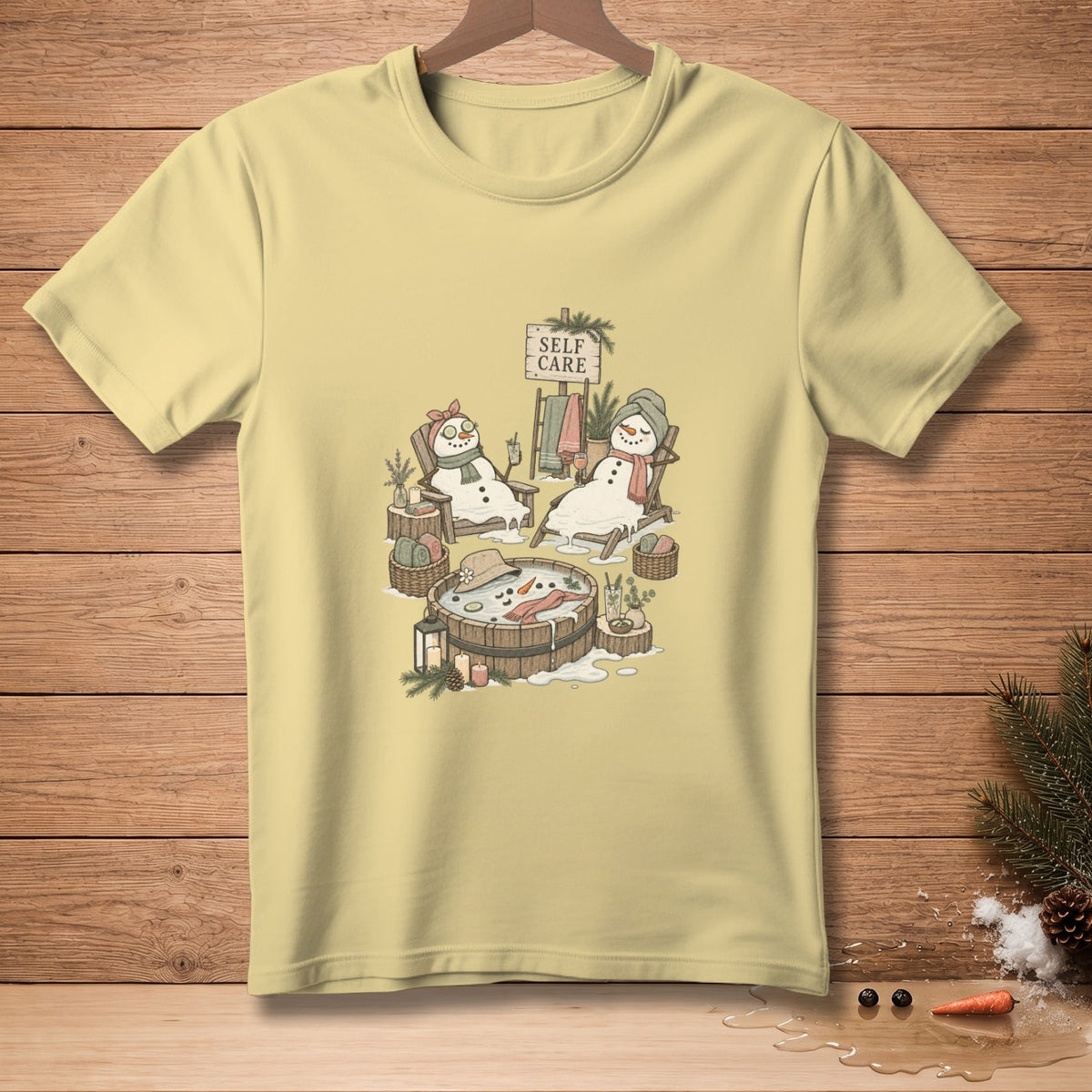 T-shirt with illustration of snowmen enjoying self-care in a hot tub and lounge chairs.