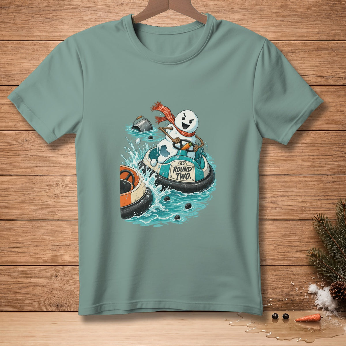 Snowman in a bumper boat with "ROUND TWO." text, on a teal t-shirt.